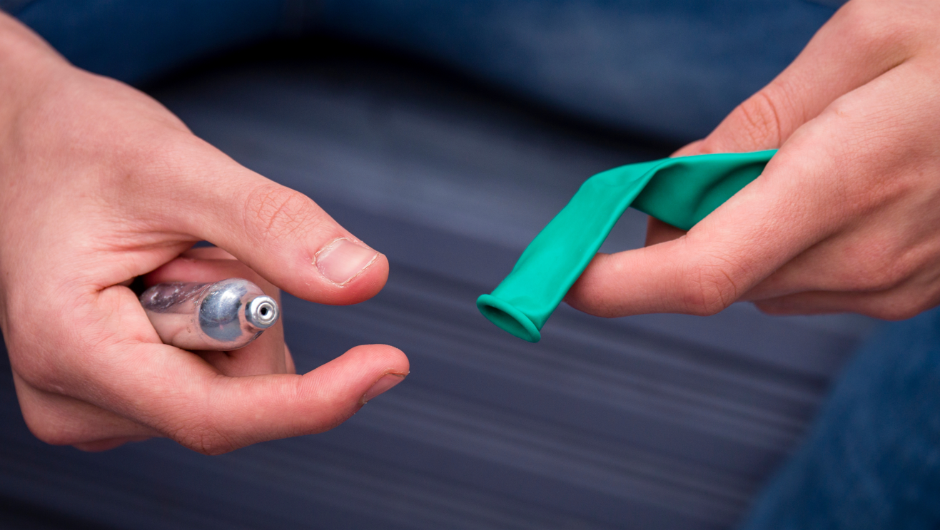 A picture of a nitrous oxide cannister and a balloon